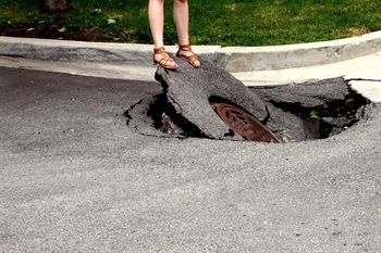 Woman standing on top of a sinkhole
