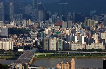 aerial view of bridge crossing river with high-rise buildings in background