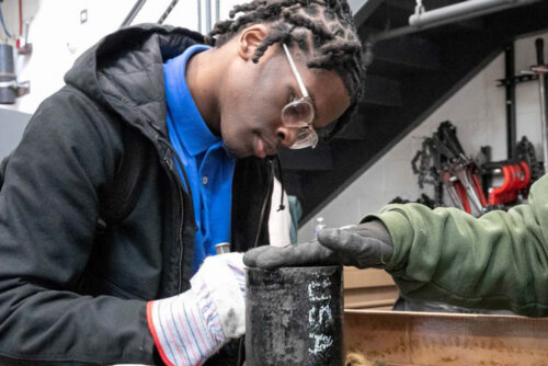 A student working with pipes at Chicago Public Shcools' Skill Trades Fair
